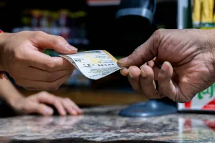 AUSTIN, TEXAS - OCTOBER 10: A customer purchases a Powerball lottery ticket at the Brew Market & Cafe on October 10, 2023 in Austin, Texas. The Powerball jackpot has grown to over $1.7 billion, making it the second largest jackpot in history. (Photo by Brandon Bell/Getty Images)
