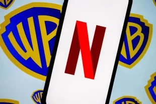 ANKARA, TURKIYE - DECEMBER 5: In this photo illustration, the logo of Netflix is displayed on a mobile phone screen in front of the logo of Warner Bros in Ankara, Turkiye on December 5, 2025. (Photo by Didem Mente/Anadolu via Getty Images)