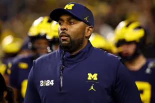 HOUSTON, TEXAS - JANUARY 8: Offensive coordinator Sherrone Moore of the Michigan Wolverines takes the field against the Washington Huskies during the 2024 CFP National Championship game at NRG Stadium on January 8, 2024 in Houston, Texas. (Photo by Jamie Schwaberow/Getty Images)
