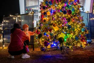 AUSTIN, TEXAS - DECEMBER 14: A family spends time together near a Christmas tree during the Austin Trail of Lights festival at Zilker Metropolitan Park on December 14, 2023 in Austin, Texas. Community members came out to participate in this year's 59th annual Austin Trail of Lights festival. (Photo by Brandon Bell/Getty Images)