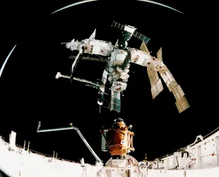 The American shuttle Atlantis docks with the Russian Space Station Mir, in order to deliver a Russian docking module and two solar arrays (Image via Getty)