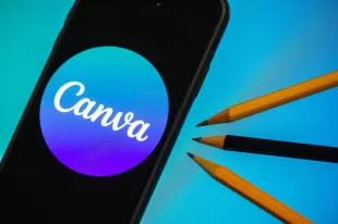 A Canva logo displayed on a smartphone and three pencils are seen in L'Aquila, Italy, on October 4th, 2023. On October 4th Canva launched "Magic Studio", its new design platoform powered by AI (Artificial Intelligence).  (Photo by Lorenzo Di Cola/NurPhoto via Getty Images)