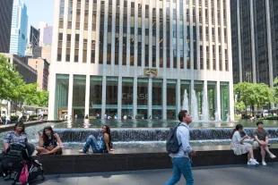 Tourists gather on a fountain outside the Manhattan headquarters of the bank JP Morgan Chase, Manhattan, New York City, New York, July, 2016. (Photo by Smith Collection/Gado/Getty Images).