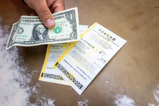 AUSTIN, TEXAS - DECEMBER 19: In this photo illustration, a clerk displays Powerball lottery tickets at a convenience store on December 19, 2025 in Austin, Texas. The Powerball jackpot climbs to $1.5 billion, making it the fifth largest in Powerball history. (Photo by Brandon Bell/Getty Images)