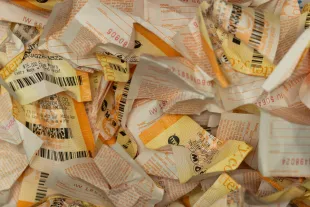 Hawthorne, CA - December 1: Crumpled up losing lottery tickets sit in a wastebasket at Bluebird Liquor on Monday, Dec. 1, 2025 in Hawthorne, CA. The Powerball jackpot has reached $740 million after no weekend winner was chosen. (Juliana Yamada / Los Angeles Times via Getty Images)