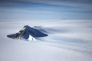 A section of the West Antarctic Ice Sheet with mountains is viewed from a window of a NASA Operation IceBridge airplane (Photo for reference, Image via Getty)