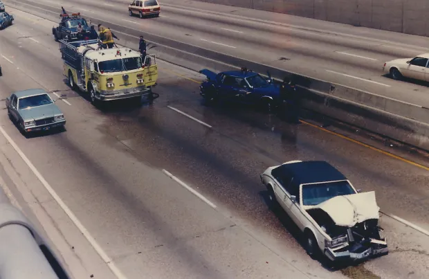 Firefighters clearing wrecked cars from the highway during a major car accident, Michigan, 1987 (Image via Getty)